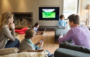 Family using electronic gadgets in a living room